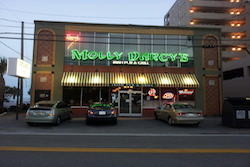 molly darcy's exterior with green neon lights and cars parked infront, pet friendly restaurant in Myrtle Beach, SC