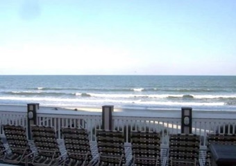 oceanfront deck and lounge area wth white railing and sun chairs, myrtle beach pet friendly vacation rental home