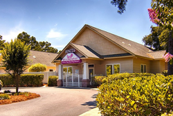 tan building with white entrance gate and circular driveway, exterior of Benji's Bed and Breakfast, daycare in myrtle beach